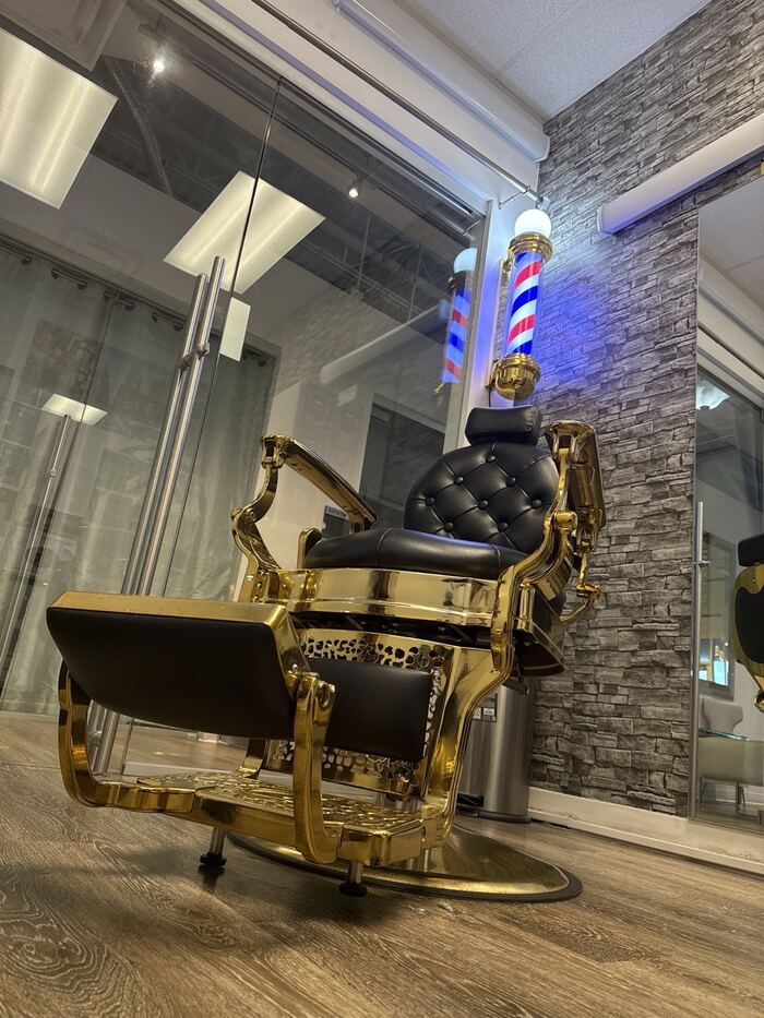 Gold barber chair and lit barber pole in Ricky's Style private suite, Royal Palm Beach FL