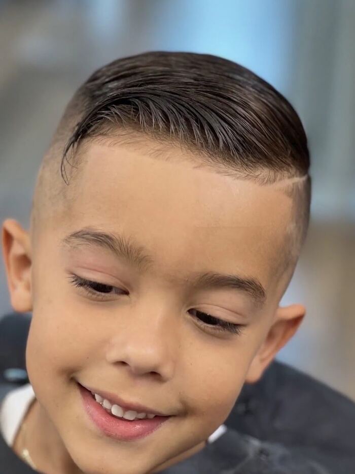 Kids' skin fade with a slick-back top and hard part at Ricky's Style Barbershop, Royal Palm Beach FL