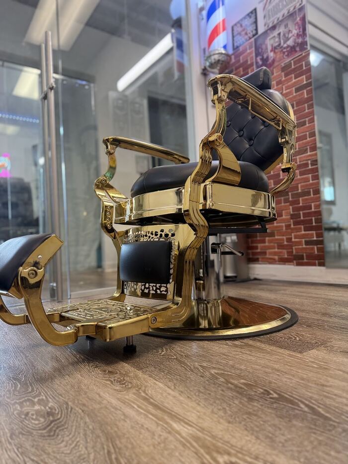 The gold and black premium barber chair in Ricky's Style private suite, Royal Palm Beach FL